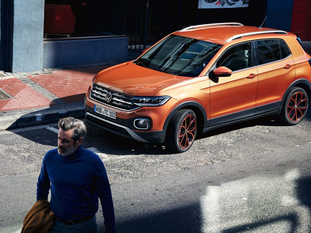 TS0217_T-Cross-in-energetic-orange-parked-on-street-with-man-walking-away_3-2_f-tr